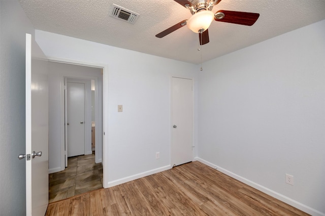 308 Crowe Dr, Euless, TX 76040 - unfurnished bedroom featuring light wood-style floors, a textured ceiling, and a ceiling fan