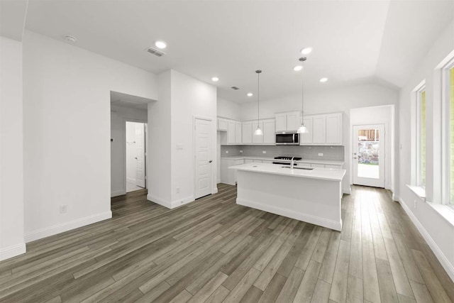 318 Boston, Princeton, TX 75407 - kitchen featuring stainless steel microwave, light countertops, white cabinets, wood finished floors, and backsplash