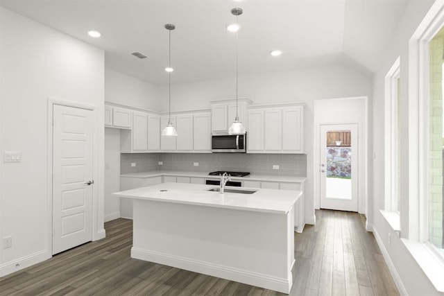 318 Boston, Princeton, TX 75407 - kitchen with stainless steel microwave, decorative backsplash, dark wood-type flooring, white cabinetry, and lofted ceiling
