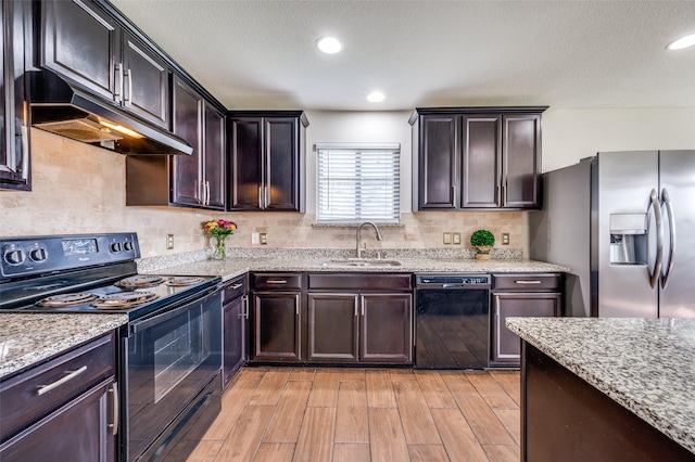 1221 Rivers Creek Ln, Little Elm, TX 75068 - kitchen with black appliances, under cabinet range hood, tasteful backsplash, light wood finished floors, and recessed lighting