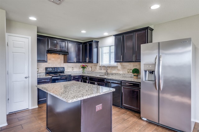 1221 Rivers Creek Ln, Little Elm, TX 75068 - kitchen with black appliances, light wood-style floors, light stone countertops, tasteful backsplash, and recessed lighting