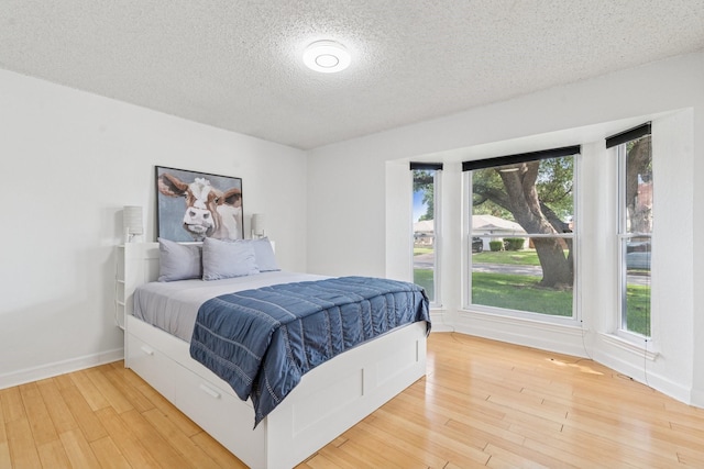 3905 Chestnut St, Fort Worth, TX 76137 - bedroom with a textured ceiling, light wood-type flooring, and multiple windows