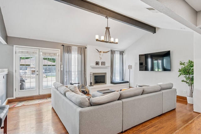 3905 Chestnut St, Fort Worth, TX 76137 - living room featuring wood finished floors, a chandelier, a glass covered fireplace, and french doors