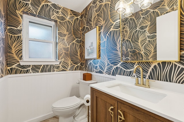 10306 Cimmaron Trl, Dallas, TX 75243 - half bath featuring wallpapered walls, a wainscoted wall, and vanity