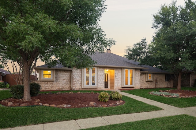 10306 Cimmaron Trl, Dallas, TX 75243 - view of front of house featuring brick siding, a front lawn, a chimney, and roof with shingles