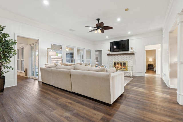 10306 Cimmaron Trl, Dallas, TX 75243 - living area featuring a ceiling fan, a brick fireplace, dark wood-type flooring, crown molding, and recessed lighting