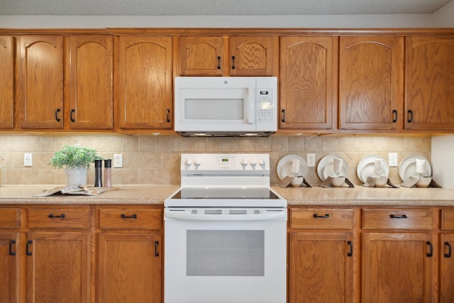 9129 Apollo Ct, Frisco, TX 75033 - kitchen with white appliances, tasteful backsplash, and brown cabinetry