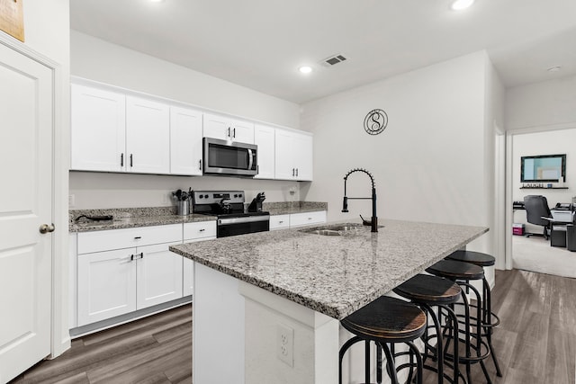 418 Madison Way, Princeton, TX 75407 - kitchen with stainless steel appliances, dark wood-type flooring, recessed lighting, light stone countertops, and a kitchen breakfast bar