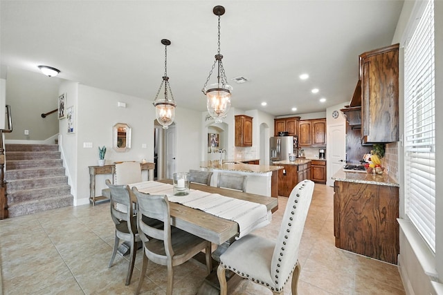 10704 Parnell Dr, Mckinney, TX 75072 - dining space with arched walkways, light tile patterned floors, recessed lighting, and stairway