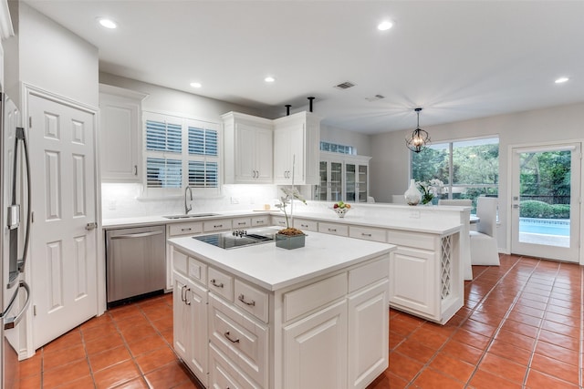 8931 Club Creek Cir, Dallas, TX 75238 - kitchen featuring stainless steel appliances, a kitchen island, light tile patterned floors, recessed lighting, and a peninsula