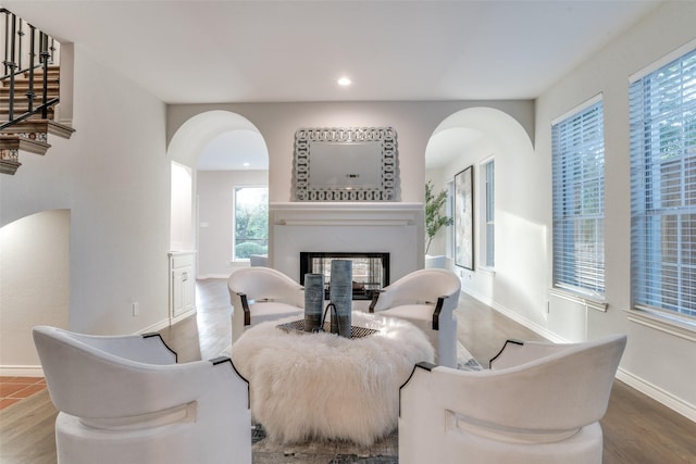 8931 Club Creek Cir, Dallas, TX 75238 - dining space with arched walkways, a glass covered fireplace, wood finished floors, recessed lighting, and stairs