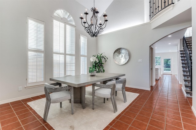 8931 Club Creek Cir, Dallas, TX 75238 - dining area featuring arched walkways, dark tile patterned flooring, a towering ceiling, and a chandelier