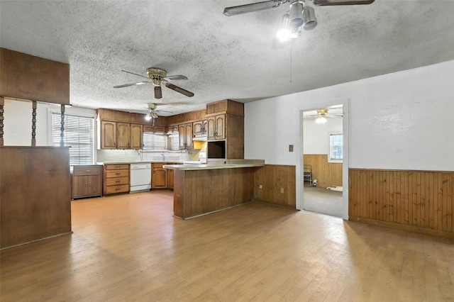 221 E 7th St, Weatherford, TX 76086 - kitchen featuring a ceiling fan, dishwasher, a wainscoted wall, light wood-type flooring, and wood walls