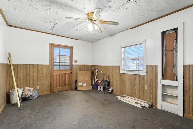 221 E 7th St, Weatherford, TX 76086 - unfurnished room with wainscoting, wood walls, plenty of natural light, carpet flooring, and a textured ceiling