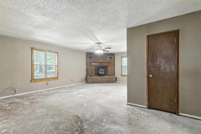 221 E 7th St, Weatherford, TX 76086 - unfurnished living room featuring unfinished concrete flooring, ceiling fan, a fireplace, and a textured ceiling