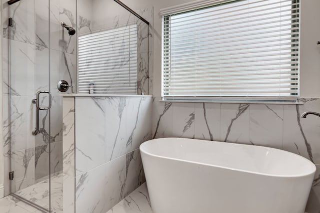 237 Gardenia Dr, Azle, TX 76020 - bathroom featuring marble tiled flooring, a freestanding tub, a marble finish shower, plenty of natural light, and tile walls