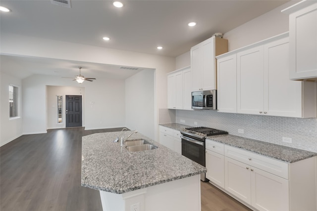 3928 Aqua Ln, Sherman, TX 75090 - kitchen with stainless steel appliances, wood finished floors, tasteful backsplash, white cabinets, and light stone countertops