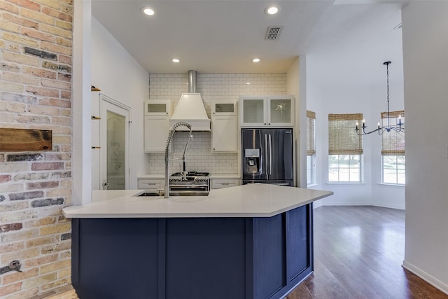 700 Stanford Dr, Waxahachie, TX 75165 - kitchen with fridge with ice dispenser, backsplash, wood finished floors, custom range hood, and light countertops