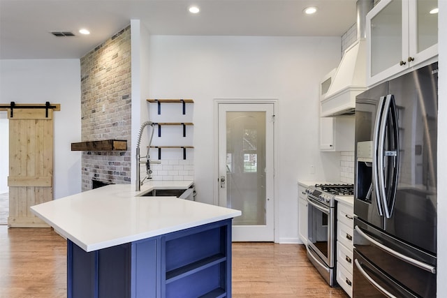 700 Stanford Dr, Waxahachie, TX 75165 - kitchen featuring appliances with stainless steel finishes, blue cabinetry, open shelves, premium range hood, and recessed lighting