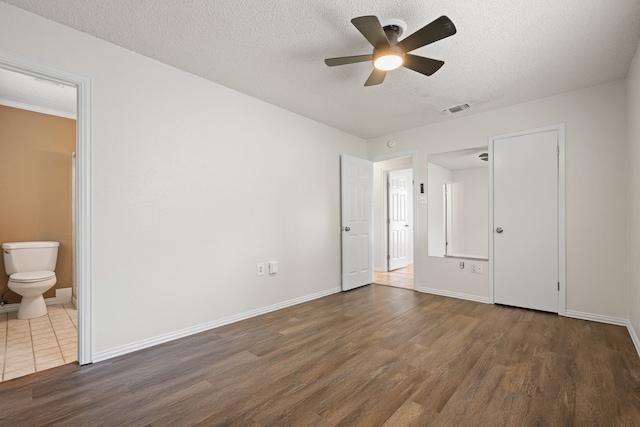 721 SW Hillside Dr, Burleson, TX 76028 - unfurnished bedroom with wood finished floors, a textured ceiling, ensuite bath, and ceiling fan