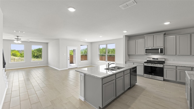 1327 Burgess St, Royse City, TX 75189 - kitchen with gray cabinets, stainless steel appliances, open floor plan, decorative backsplash, and recessed lighting