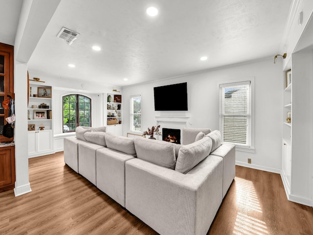 3921 Bryce Ave, Fort Worth, TX 76107 - living area featuring a warm lit fireplace, light wood-type flooring, recessed lighting, and built in shelves