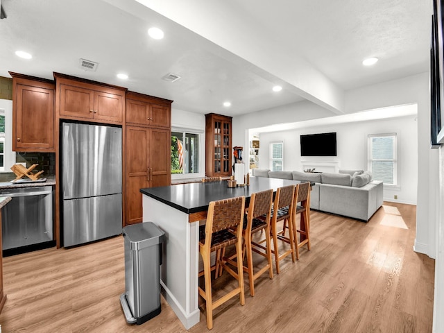 3921 Bryce Ave, Fort Worth, TX 76107 - kitchen featuring stainless steel appliances, light wood-style flooring, healthy amount of natural light, recessed lighting, and beamed ceiling
