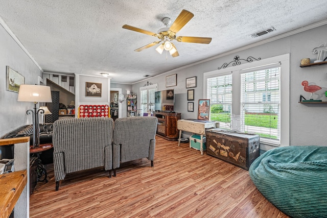 814 N Ollie St, Stephenville, TX 76401 - living area featuring wood finished floors, ornamental molding, a textured ceiling, and a ceiling fan