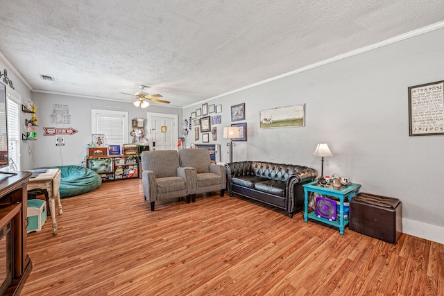 814 N Ollie St, Stephenville, TX 76401 - living room featuring a textured ceiling, crown molding, light wood finished floors, and ceiling fan