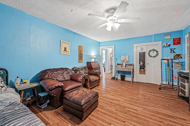 814 N Ollie St, Stephenville, TX 76401 - living area featuring a textured ceiling, light wood-type flooring, and ceiling fan