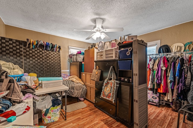 814 N Ollie St, Stephenville, TX 76401 - bedroom with a textured ceiling, wood finished floors, a textured wall, and a ceiling fan