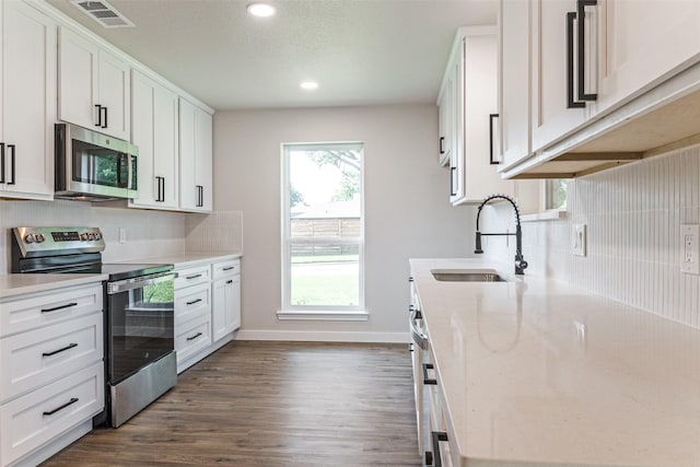 707 Lake Meadows Dr, Rockwall, TX 75087 - kitchen featuring stainless steel appliances, tasteful backsplash, recessed lighting, dark wood finished floors, and white cabinetry