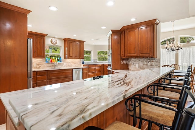 750 Emerald Sound Blvd, Oak Point, TX 75068 - kitchen with appliances with stainless steel finishes, brown cabinets, recessed lighting, plenty of natural light, and decorative backsplash
