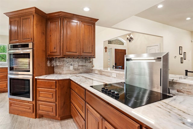 750 Emerald Sound Blvd, Oak Point, TX 75068 - kitchen with double oven, brown cabinetry, tasteful backsplash, recessed lighting, and black electric stovetop