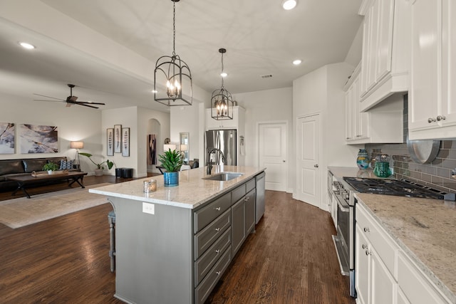 1105 Denton Creek Dr, Justin, TX 76247 - kitchen featuring appliances with stainless steel finishes, gray cabinets, arched walkways, recessed lighting, and open floor plan