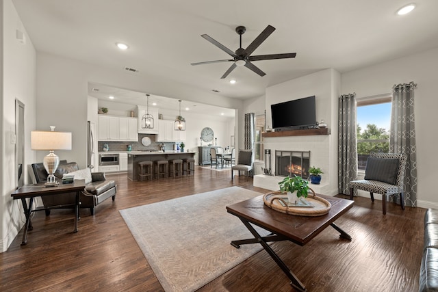 1105 Denton Creek Dr, Justin, TX 76247 - living room featuring a ceiling fan, dark wood-style flooring, a brick fireplace, and recessed lighting