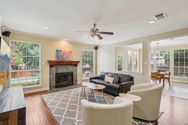 6903 Glenview Ln, Colleyville, TX 76034 - living area with healthy amount of natural light, ceiling fan, a tiled fireplace, a chandelier, and crown molding