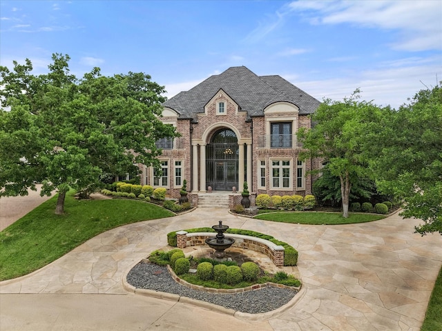 5106 Oak Ln, Arlington, TX 76017 - french country home featuring french doors, brick siding, a high end roof, and a front yard