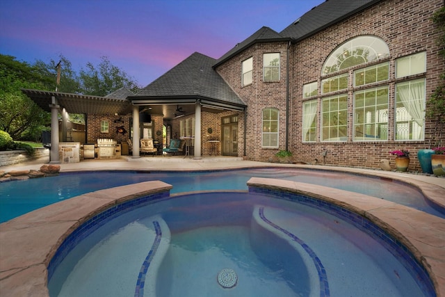 5106 Oak Ln, Arlington, TX 76017 - pool at dusk featuring a pool with connected hot tub, a patio, and ceiling fan