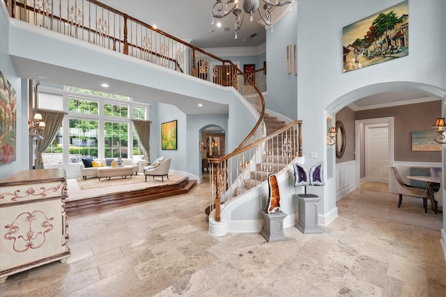 5106 Oak Ln, Arlington, TX 76017 - entryway with arched walkways, a towering ceiling, a chandelier, stone tile flooring, and ornamental molding