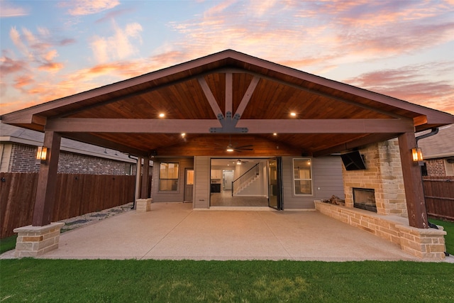 1424 Archway Ct, Fort Worth, TX 76247 - patio terrace at dusk featuring an outdoor fireplace, a patio area, and a ceiling fan