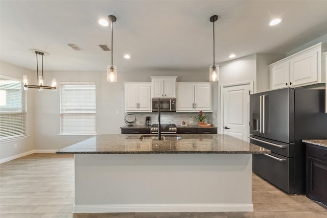 1424 Archway Ct, Fort Worth, TX 76247 - kitchen with stainless steel appliances, dark stone counters, light wood-style floors, and recessed lighting