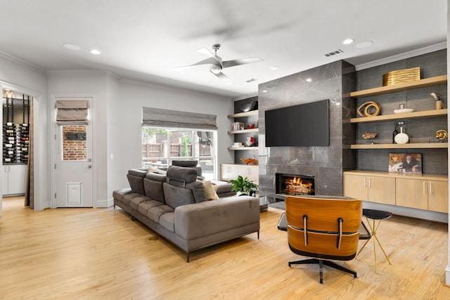 5912 Lindfield Ct, Plano, TX 75093 - living area featuring a ceiling fan, light wood finished floors, ornamental molding, recessed lighting, and a fireplace