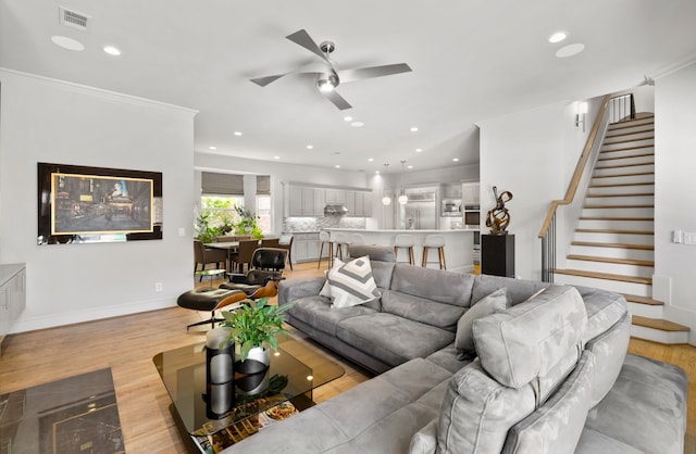5912 Lindfield Ct, Plano, TX 75093 - living room featuring light wood-style flooring, a ceiling fan, stairs, recessed lighting, and ornamental molding