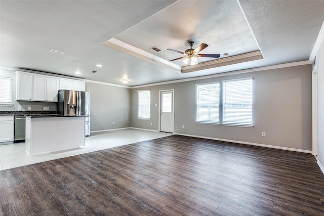 3109 Layla Creek Dr, Little Elm, TX 75068 - unfurnished living room featuring ornamental molding, ceiling fan, wood finished floors, a tray ceiling, and recessed lighting
