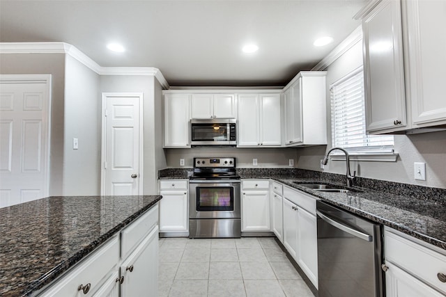 3109 Layla Creek Dr, Little Elm, TX 75068 - kitchen with appliances with stainless steel finishes, ornamental molding, white cabinetry, dark stone countertops, and light tile patterned floors