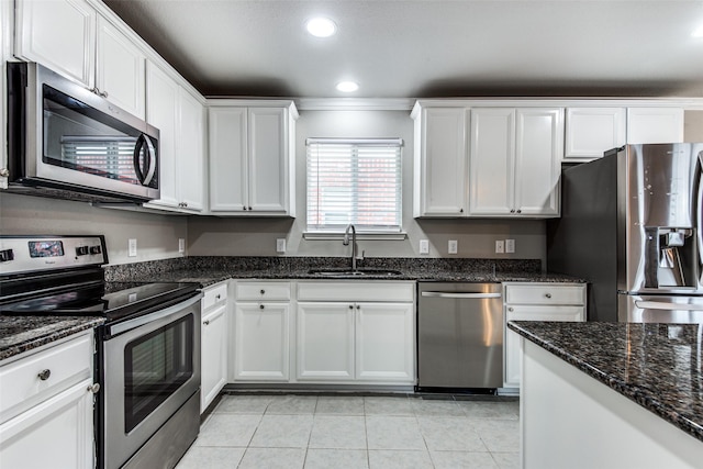 3109 Layla Creek Dr, Little Elm, TX 75068 - kitchen featuring appliances with stainless steel finishes, light tile patterned floors, white cabinets, recessed lighting, and dark stone countertops