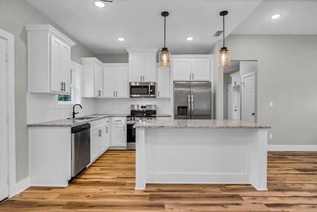 1002 E Main, Whitehouse, TX 75791 - kitchen featuring stainless steel appliances, light wood finished floors, white cabinetry, a kitchen island, and recessed lighting