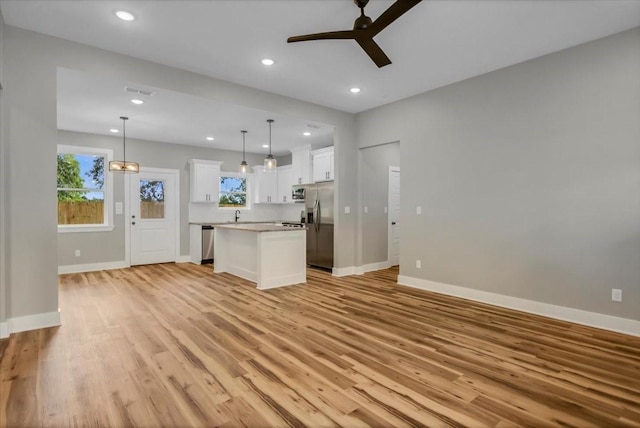 1002 E Main, Whitehouse, TX 75791 - unfurnished living room featuring a ceiling fan, light wood-type flooring, plenty of natural light, and recessed lighting