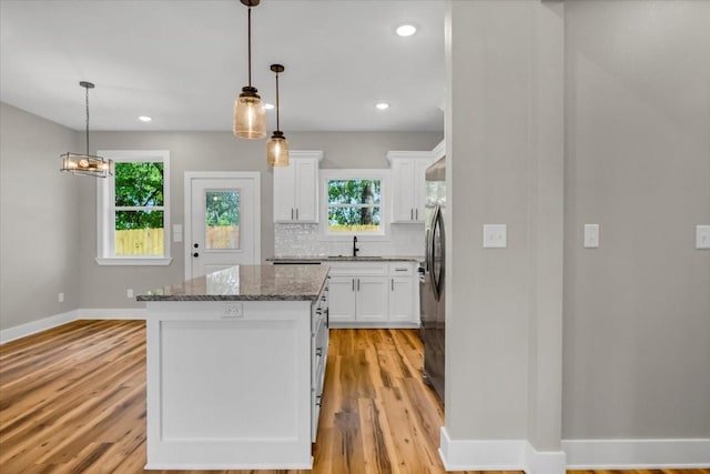 1002 E Main, Whitehouse, TX 75791 - kitchen with plenty of natural light, a kitchen island, white cabinets, light wood-style flooring, and recessed lighting